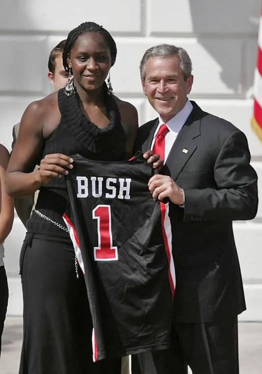 President George W. Bush stands with Crystal Langhorne, captain of the University of Maryland Women's Basketball Team, during a South Lawn ceremony honoring the 2005 and 2006 NCAA champions Thursday, April 6, 2006. The University of Maryland also won national titles in women's field hockey and men's soccer. White House photo by Paul Morse