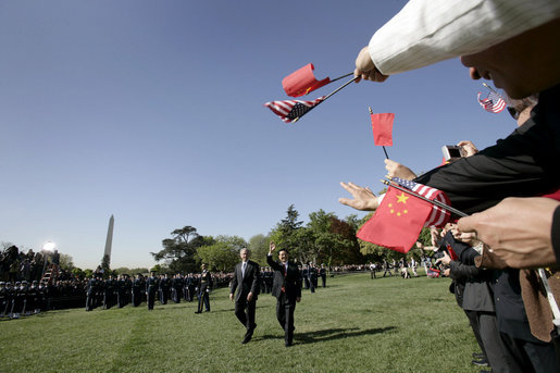 Guests wave flags for Presidents George W. Bush and Hu Jintao during an arrival ceremony held on the South Lawn for the Chinese President, Thursday, April 20, 2006. White House photo by Eric Draper