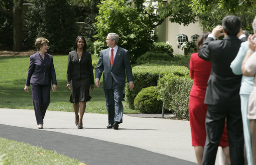 President George W. Bush and Mrs. Laura Bush accompany 2006 National Teacher of the Year Kim Oliver to the South Lawn ceremony in her honor Wednesday, April 26, 2006. Said the President of the Silver Spring, Maryland kindergarten teacher, "Kim Oliver understands that the key to helping children succeed is fighting the soft bigotry of low expectations." White House photo by Paul Morse