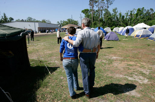 President George W. Bush walks with Hands On Network Disaster Response Coordinator Erika Putinsky during a tour of their base camp in Biloxi, Mississippi, Thursday, April 27, 2006. White House photo by Eric Draper