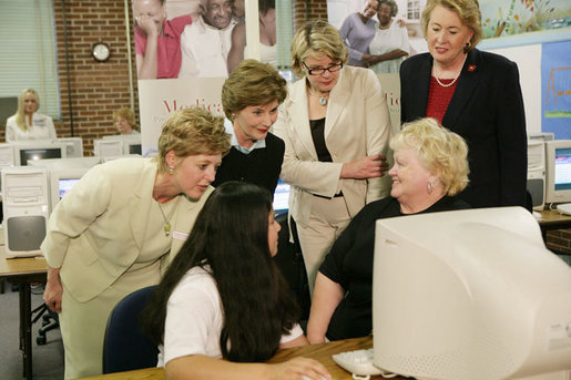 Mrs. Laura Bush and U.S. Department of Education Secretary Margaret Spellings, center, look at computer information with St. Boniface sixth-graders and senior citizens Tuesday, May 2, 2006 in Ft. Smith, Ark., to remind seniors of the May 15th enrollment deadline to sign-up for the Medicare Prescription Drug Benefit. White House photo by Shealah Craighead