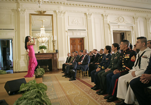 President George W. Bush and guests listen to artist Graciela Beltran perform during the White House celebration of Cinco De Mayo in the East Room Thursday, May 4, 2006. White House photo by Paul Morse