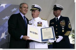 President George W. Bush presents Admiral Tom Collins, center, and Master Chief Petty Officer Frank Welch with the Presidential Unit Citation, Thursday, May 25, 2006 at Fort Lesley J. McNair in Washington, D.C., during the Change of Command Ceremony for the Commandant of the United States Coast Guard. White House photo by Eric Draper