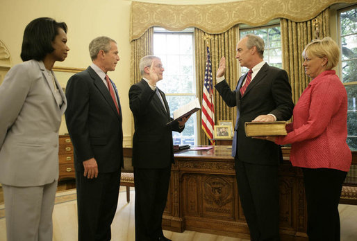 President George W. Bush is joined by Secretary of State Condoleezza Rice as Idaho Gov. Dirk Kempthorne is sworn into office as Secretary of the Interior by Chief of Staff Josh Bolten Friday, May 26, 2006. Mrs. Patricia Kempthorne holds the Kempthorne family Bible for the ceremony that was held in the Oval Office of the White House. White House photo by Eric Draper