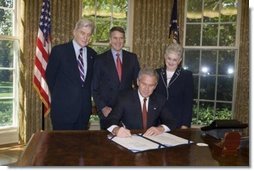 President George W. Bush is joined by Senator John Warner, R-Va, left, Senator Bill Frist, R-TN, center, and Congresswoman Virginia Foxx, R-NC, as he signs H.R. 1499, the Heroes Earned Retirement Opportunities Act, in the Oval Office Monday, May 29, 2006. White House photo by Paul Morse
