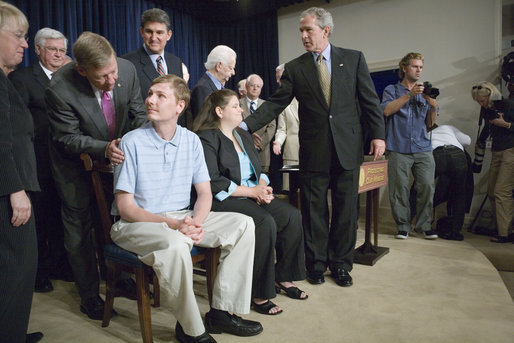 President George W. Bush greets Anna McCloy, wife of miner Randal McCloy, during the signing of S. 2803, The MINER Act, in the Dwight D. Eisenhower Executive Office Building Thursday, June 15, 2006. Sen. Johnny Isakson, R-Ga., greets Randal McCloy. "This year alone, accidents have taken the lives of 33 miners in our country," said President Bush. "Just last month, five miners were killed in a mine explosion in Harlan County, Kentucky. And in January, Americans watched and prayed -- a lot of Americans prayed -- with the people of West Virginia for the 13 miners that were trapped underground by the explosion in the Sago mine. Only one man came out, and he's with us today -- Randal McCloy, and his wife, Anna. And we welcome you all." White House photo by Eric Draper