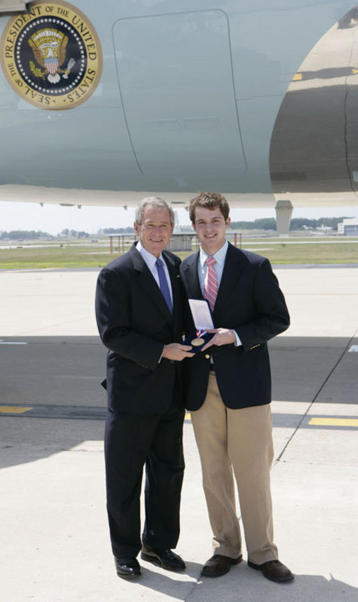 President George W. Bush presents the 2006 Presidential Scholars medal to Andrew Benecke, 18, Wednesday, June 28, 2006 at Lambert Field in St. Louis, Mo. Benecke was unable to attend the awards ceremony in Washington earlier this month because he was undergoing chemotherapy in his fight against bone cancer. White House photo by Kimberlee Hewitt