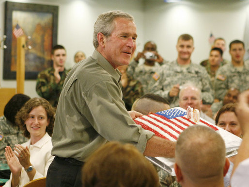 President George W. Bush is presented with a birthday cake in honor of his upcoming 60th birthday, at a luncheon with troops Tuesday, July 4, 2006, at Fort Bragg in North Carolina. President Bush earlier addressed the troops at an Independence Day celebration thanking them for their service to the nation. White House photo by Paul Morse