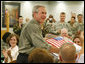 President George W. Bush is presented with a birthday cake in honor of his upcoming 60th birthday, at a luncheon with troops Tuesday, July 4, 2006, at Fort Bragg in North Carolina. President Bush earlier addressed the troops at an Independence Day celebration thanking them for their service to the nation. White House photo by Paul Morse