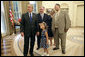 President George W. Bush and 5-year-old Alexa Ostolaza, the 2006 March of Dimes National Ambassador, peek out an Oval Office window for the President's dogs Thursday, July 6, 2006. With them, from left, are Jim Sproull Jr., Chairman of the Board of the March of the Dimes, and Alexa's parents Jessica and Josue Ostolaza. White House photo by Kimberlee Hewitt