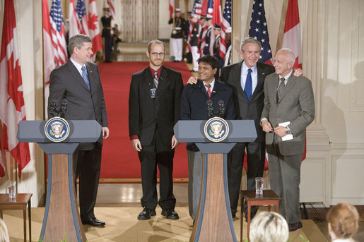 After holding a press conference with Canadian Prime Minister Stephen Harper, President George W. Bush poses with fellow birthday celebrants in the East Room Thursday, July 6, 2006. The President celebrates his 60th birthday today. Pictured with him are, from left. Todd Mizis of the U.S. State Department; Raghubir Goyal of the India Globe and Asia Today; and Richard Benedetto of USA Today. White House photo by Kimberlee Hewitt