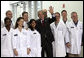 President George W. Bush stands with a group of employees as he waves to others during a tour of the Cabot Microelectronics Corporation facility in Aurora, Ill., Friday, July 7, 2006. White House photo by Eric Draper
