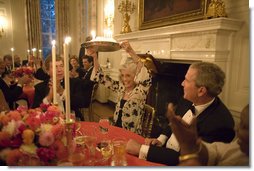 President George W. Bush watches Eunice Kennedy Shriver holding up a birthday cake during a dinner honoring her 85th birthday in the State Dining Room of the White House, Monday, July 10, 2006. Mrs. Shriver founded the Special Olympics in 1968.  White House photo by Paul Morse