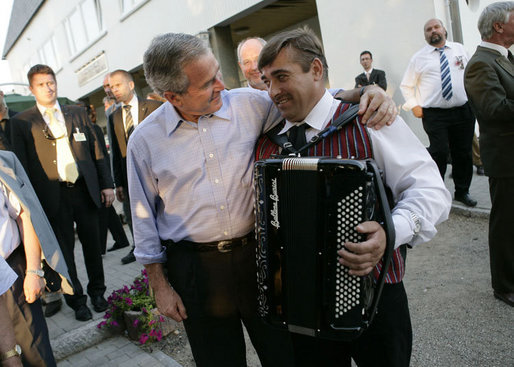 President George W. Bush puts his arm around an accordian player Thursday, July 13, 2006, after an evening barbeque in Trinwillershagen, Germany, hosted by Chancellor Angela Merkel. White House photo by Eric Draper