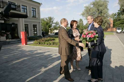 President George W. Bush and Laura Bush are greeted by Russian President Vladimir Putin and his wife, Lyudmila, upon their arrival Friday, July 14, 2006, for a social dinner at the Konstantinovsky Palace in Strelna, Russia. White House photo by Eric Draper