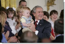 President George W. Bush holds 14-month-old Trey Jones of Cypress, Texas, following his remarks about stem cell research policy legislation in the East Room of the White House Wednesday, July 19, 2006. "Each of these children was adopted while still an embryo, and has been blessed with the chance to grow up in a loving family," said the President of children sharing the stage with him. "These boys and girls are not spare parts. They remind us of what is lost when embryos are destroyed in the name of research." Trey Jones was first introduced to the President during a White House visit in May 2005. White House photo by Kimberlee Hewitt