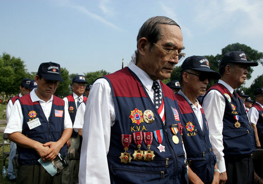 Members of the Korean War Veterans Association bow their heads during the invocation at the 2006 Korean War Veterans Armistice Day Ceremony, Thursday, July 27, 2006, at the Korean War Memorial in Washington, D.C. White House photo by David Bohrer