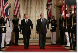 President George W. Bush is joined by Prime Minister Tony Blair of the United Kingdom as they walk through Cross Hall to the East Room of the White House Friday, July 28, 2006, to participate in a joint press availability. White House photo by Paul Morse