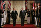 President George W. Bush is joined by Prime Minister Tony Blair of the United Kingdom as they walk through Cross Hall to the East Room of the White House Friday, July 28, 2006, to participate in a joint press availability. White House photo by Paul Morse