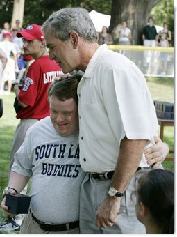 President George W. Bush embraces a South Lawn buddy volunteer Sunday, July 30, 2006, on the South Lawn of the White House at the conclusion of the Tee Ball on the South Lawn game between the Thurmont Little League Civitan Club of Frederick Challengers of Thurmont, Md., and the Shady Spring Little League Challenger Braves of Shady Spring, W. Va.  White House photo by Paul Morse