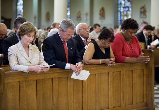 President George W. Bush and Laura Bush bow their heads in prayer Tuesday, Aug. 29, 2006, during a service at New Orleans' St. Louis Cathedral commemorating the first anniversary of Hurricane Katrina. Joining them are Ethel Williams, a 9th Ward resident, and her sister, Wanda. White House photo by Eric Draper