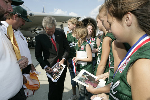 President George W. Bush signs autographs as he meets with members of the 2006 Little League Softball World Series Champions at Bishop International Airport before departing Flint, Mich. White House photo by Kimberlee Hewitt