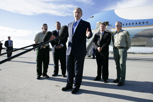 President George W. Bush stands with California forestry officials as he delivers a statement Tuesday, Oct. 3, 2006, at Los Angeles International Airport regarding the state's wildfires. The President told the crowd, "I really want to thank the brave firefighters who risk their lives on a daily basis to contain the fires." White House photo by Eric Draper