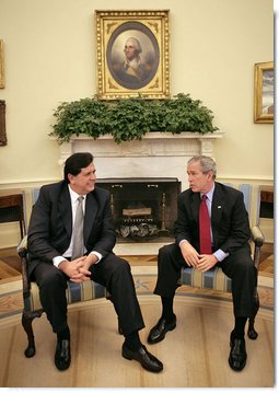 President George W. Bush talks with President Alan Garcia of Peru in the Oval Office Tuesday, Oct. 10, 2006. “We talked about world issues, we talked about issues regarding South America and Central America, and we talked about our bilateral relations,” said President Bush in his remarks to the press. “The central issue facing us right now is the passage of a free trade agreement.”  White House photo by Eric Draper