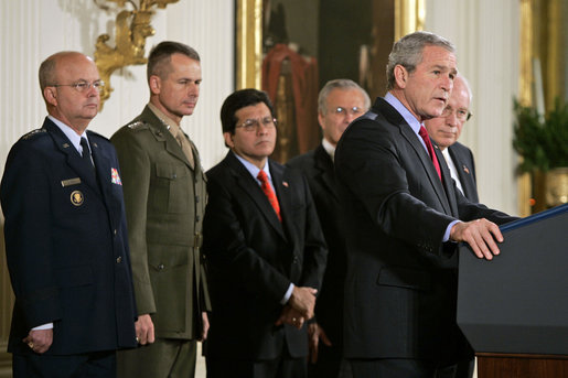 President George W. Bush speaks during the signing of S. 3930, the Military Commissions Act of 2006, Tuesday, Oct. 17, 2006, in the East Room. "It is a rare occasion when a President can sign a bill he knows will save American lives. I have that privilege this morning," said President Bush. Pictured in the background are, from left, Deputy Director of National Intelligence Michael Hayden; General Peter Pace, Chairman of the Joint Chiefs of Staff; Attorney General Alberto Gonzales; Defense Secretary Donald Rumsfeld and Vice President Dick Cheney. White House photo by Paul Morse