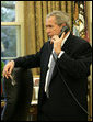 President George W. Bush makes a telephone call Friday, Oct. 27, 2006, to Tom Tidwell, Deputy Regional Forester, about the deaths Thursday of four firefighters in a Southern California wildfire. The firefighters were killed while battling the Esperanza fire near Palm Springs. White House photo by Paul Morse