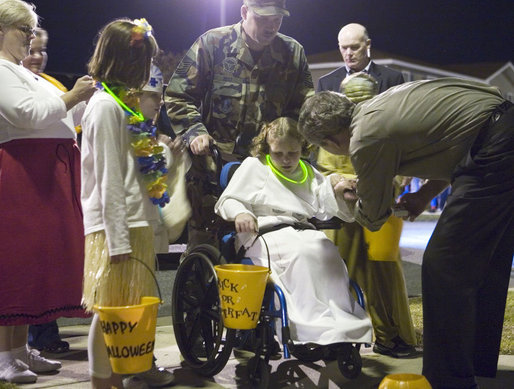 President George W. Bush greets a trick-or-treater Tuesday, Oct. 31, 2006, during an unexpected stop on base at Robins Air Force Base, Ga. White House photo by Paul Morse