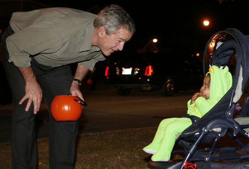 President George W. Bush greets a trick-or-treating frog Tuesday, Oct. 31, 2006, during an unscheduled stop on base at Robins Air Force Base in Warner Robins, Ga. White House photo by Paul Morse