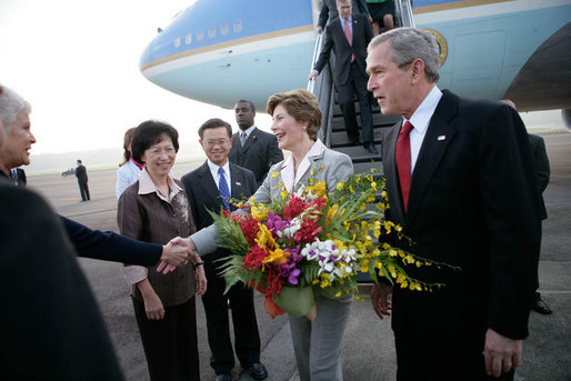 President George W. Bush looks on as Laura Bush is greeted by Patricia L. Herbold, U.S. Ambassador to Singapore, upon their arrival at Paya Lebar Airport Thursday, Nov. 16, 2006, for a two-day visit. White House photo by Eric Draper