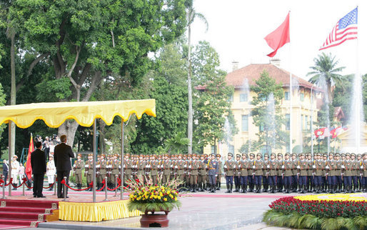 President George W. Bush and President Nguyen Minh Triet of Vietnam, stand at attention during the playing of the national anthems Friday, Nov. 17, 2006, during the arrival ceremony for the President and Mrs. Bush at the Presidential Palace in Hanoi. White House photo by Shealah Craighead