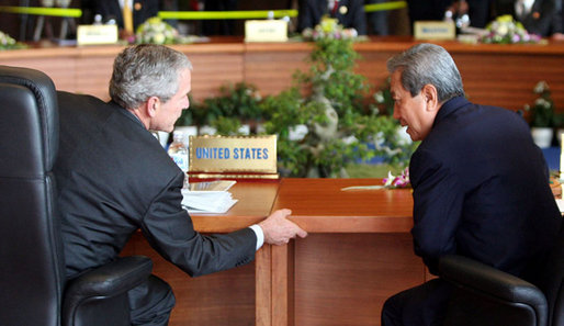 President Bush leans in to talk with Prime Minister Surayud Chulanont of Thailand during the first retreat of APEC leaders Saturday, Nov. 18, 2006, at the National Conference Center in Hanoi. White House photo by Eric Draper