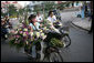 Vendors on mopeds carry flowers for sale early Saturday morning, Nov. 18, 2006, in Hanoi. White House photo by Paul Morse