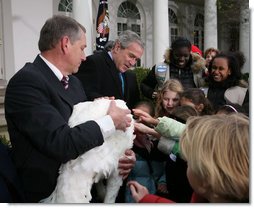 President George W. Bush invites children to meet “Flyer” the turkey, held by Lynn Nutt of Springfield, Mo., during a ceremony Wednesday, Nov. 22, 2006 in the White House Rose Garden, following the President’s pardoning of the turkey before the Thanksgiving holiday. White House photo by Paul Morse