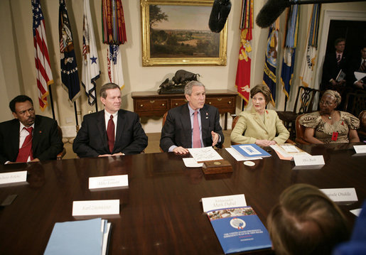 President George W. Bush talks with reporters at a meeting hosted by President Bush and Laura Bush on World AIDS Day in the Roosevelt Room at the White House, Friday, Dec. 1, 2006. President Bush said the United States is committed in helping solve this problem by dedicating a lot of resources to battle against HIV/AIDS around the world. President Bush is seen with, from left to right, Dr. Getachew Feleke of the Nassau U. Medical Center of Farmingdale, N.Y.; U.S. Secretary of Health and Human Resources, Michael O. Leavitt and Angelina Magaga, right, of the Light and Courage Center Trust of Botswana, Africa. White House photo by Eric Draper