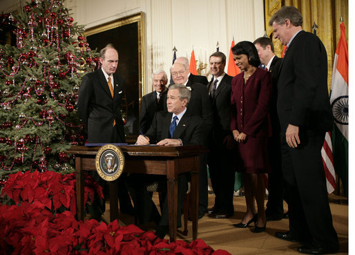 President George W. Bush is joined by U.S. Secretary of State Condoleezza Rice and U.S. legislators, as he signs H.R. 5682 The United States-India Peaceful Atomic Cooperation Act, Monday, Dec. 18, 2006, in the East Room of the White House. H.R. 5682 will allow the U.S. and India to share civilian nuclear technology and bring India’s civilian nuclear program under the safeguards of the International Atomic Energy Agency. White House photo by Eric Draper