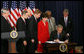 President George W. Bush signs H.R. 6407, the Postal Accountability and Enhancement Act, Wednesday, Dec. 20, 2006, at the Eisenhower Executive Office Building in Washington, D.C., joined by, from left to right, Postmaster General Jack Potter, Sen. Thomas Carper of Delaware, James C. Miller III, Chairman of the Postal Service Board of Governors; Rep. Tom Davis of Virginia, Sen. Susan Collins of Maine, Rep. Danny Davis of Illinois and Rep. John McHugh of New York. White House photo by Eric Draper
