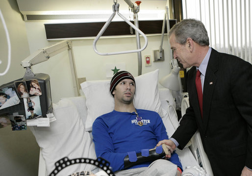 President George W. Bush congratulates U.S. Army Pvt. First Class Jace Badia of Tampa, after presenting him with a Purple Heart Friday, Dec. 22, 2006, during a visit to Walter Reed Army Medical Center where the soldier is recovering from injuries suffered in Operation Iraqi Freedom. White House photo by Eric Draper