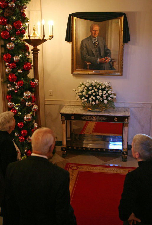 Visitors to the White House look at the portrait of former President Gerald R. Ford is draped with a black cloth in the Cross Hall of the White House Wednesday, Dec. 27, 2006. President Ford passed away Tuesday evening, Dec. 26. The portrait was painted by artist Everett Raymond Kinstler in 1977. 