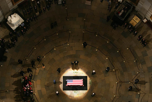 President George W. Bush and Mrs. Laura Bush stand at the side of his flag-draped coffin as they pay their respects to the late President Gerald R. Ford Monday, Jan. 1, 2007, in the Rotunda of the U.S. Capitol. White House photo by Shealah Craighead