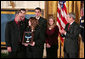 President George W. Bush presents the Medal of Honor to the family of Corporal Jason Dunham of the Marine Corps during a ceremony in the East Room Thursday, Jan. 11, 2007. The President spoke of Cpl. Dunham, "In April 2004, during an attack near Iraq's Syrian border, Corporal Dunham was assaulted by an insurgent who jumped out of a vehicle that was about to be searched. As Corporal Dunham wrestled the man to the ground, the insurgent rolled out a grenade he had been hiding. Corporal Dunham did not hesitate. He jumped on the grenade, using his helmet and body to absorb the blast. Although he survived the initial explosion, he did not survive his wounds. But by his selflessness, Corporal Dunham saved the lives of two of his men, and showed the world what it means to be a Marine." White House photo by Paul Morse