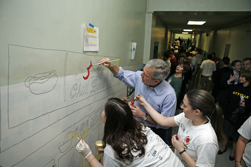 President George W. Bush lends a hand and his best brush strokes at Cardozo Senior High School in Washington, D.C., as volunteers spend Martin Luther King, Jr. Day painting murals of historical figures and local landmarks like the front of "Ben’s Chili Bowl" Monday, Jan. 15, 2007. White House photo by Paul Morse