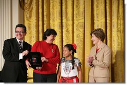 Mrs. Laura Bush presents Alicia Guadalupe Montero Perez, left, and Ingrid Janet Noh Canto, center, of La Chacara Children's Cultural Center a Coming Up Taller Award during a ceremony in the East Room Monday, Jan. 22, 2007. Gilberto Palmerin of the US-Mexico Foundation for Culture is pictured at the far left. Each year, the Coming Up Taller Awards recognize and reward excellence in community arts and humanities programs for underserved children and youth. White House photo by Shealah Craighead