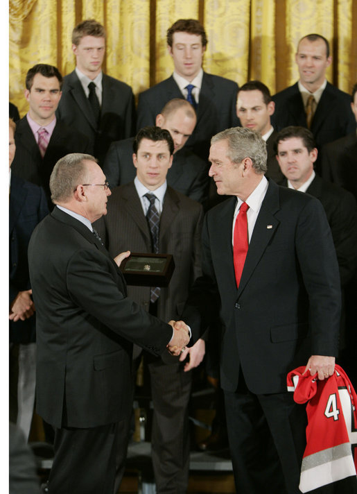 President George W. Bush shakes hands with Jim Rutherford, president and general manager of the Carolina Hurricanes hockey team, winners of the 2006 Stanley Cup, as Rutherford presents President Bush with a championship ring Friday, Feb. 2, 2007 in the East Room at the White House. White House photo by Paul Morse