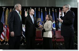 President George W. Bush stands with Director of National Intelligence J. Michael “Mike” McConnell during his ceremonial swearing-in Tuesday, Feb. 20, 2007 at Bolling Air Force Base in Washington, D.C., taking his oath from White House Chief of Staff Josh Bolten , as McConnell’s wife, Terry, holds the Bible.  White House photo by Paul Morse