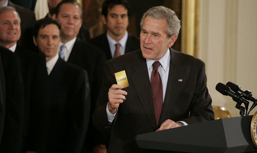 President George W. Bush holds up a card saying "15 Strong," this year's motto for the 2006 NBA champion Miami Heat, during the team's visit Tuesday, Feb. 27, 2007 to the White House. Said the President, "They had the stars. but it was the capacity to play together, to put the team ahead of themselves, that enabled them to be here at the White House." White House photo by Paul Morse