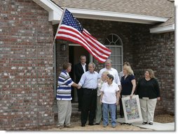 President George W. Bush shakes hands with Ernie Woodward of Long Beach, Miss. after Woodward, joined by his family, raised a flag given to them by President Bush outside his home Thursday, March 1, 2007, during the President’s tour of the neighborhood where some homes damaged by Hurricane Katrina have been rebuilt with Gulf Coast grant money.  White House photo by Eric Draper